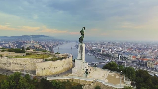 Flying around of Statue of Liberty with the skyline of Budapest at background. Budapest, Hungary - 4K aerial footage at sunrise