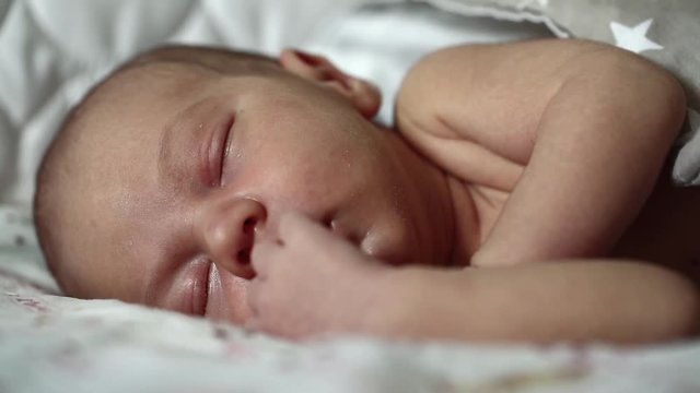 Newborn 2 weeks old baby boy lies on the bed and sleeps