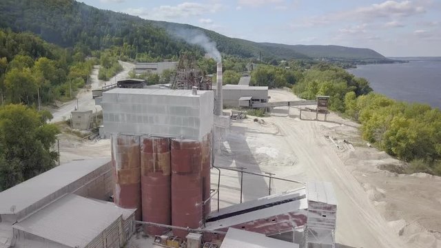 camera is flying up over plant of processing of limestone in summer day