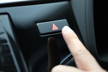 Finger hitting button emergency in the car.