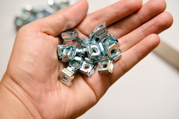Rack mounting equipment Cage nuts with Rack Studs on the hand of the engineer.