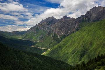 Alpine forest and mountains in Huanglong Scenic Area, Sichuan Province China. Beautiful and exotic natural geological landforms caused by erosion over time, Chinese yellow dragon natural terraces