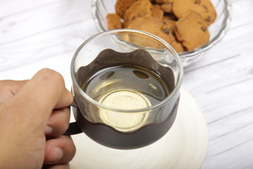 Men's hand holding a cup that contain green tea to drink