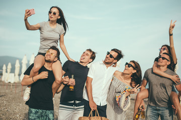 Friends on beach walking, having fun, dancing, couples hugging