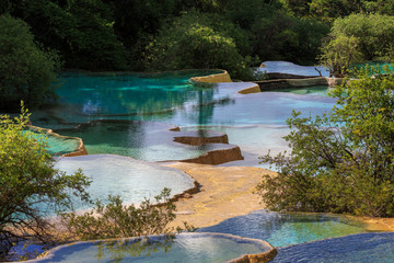 Pools of colorful blue water in Huanglong Scenic Area in Sichuan Province, China. Beautiful and...