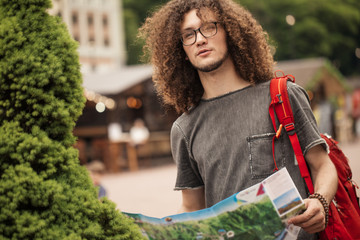 travel, tourism concept. man traveling with backpack and map in city searching location