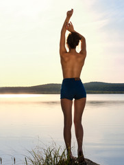 Fototapeta na wymiar girl at sunset on the lake