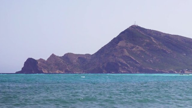 Punta Bombarda Cape and mediterranean sea from the town of Altea, Costa Blanca, Spain. Wave crushing coast. Panning view
