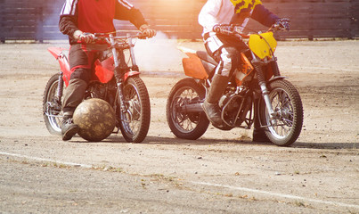 Motoball, teens play motoball on motorcycles with a ball, two players - obrazy, fototapety, plakaty
