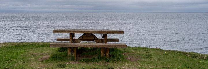 Fototapeta na wymiar Empty wooden bench with view over fjord in Iceland
