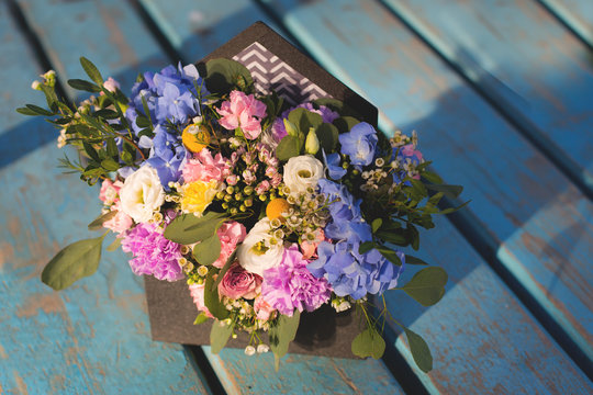 Image of beautiful flowers arrangement with hydrangea, white eustoma, spray roses, carnations on the blue wooden table