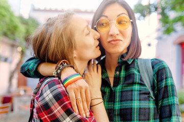 Happy lesbian couple wearing rainbow bracelet