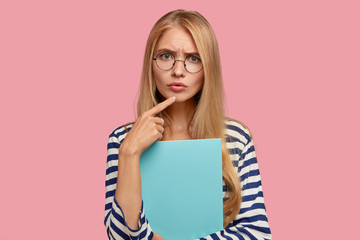 Photo of good looking woman scientist with attentive concentrated gaze, listens with serious...