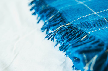 Soft, cozy blue blanket on white wooden background. Autumn comfort, space for text, top view flat...