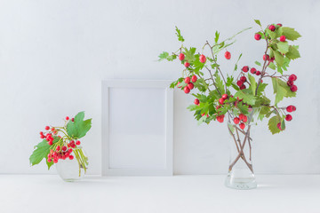 Mockup white frame and branches with red berries