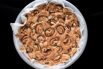 Top view on homemade plum cake with english walnuts
