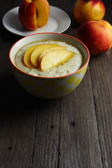Oat porridge with sliced of nectarine and honey