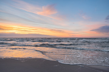 Fototapeta na wymiar Sunset on Baltic Sea white pastel color sky and rough sea. 