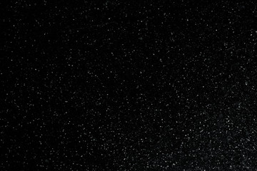 closeup background texture of snowflakes during a snowfall on a black background