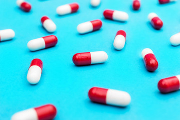 Red-white pills on blue as medical background.
