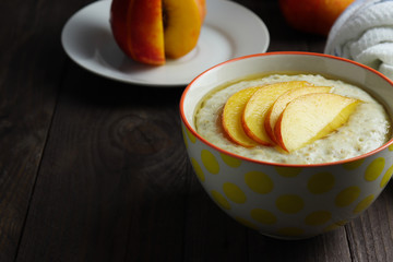 Oat porridge with sliced of nectarine and honey