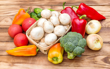 Heap of different vegetables on the wooden table.
