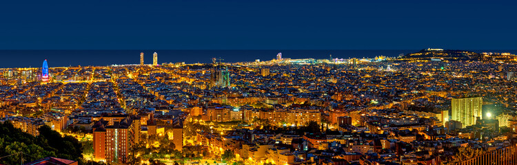 Obraz premium Barcelona skyline at night looking towards the sea showing emblematic buildings such as Agbar tower, Sagrada Familia, W hotel, Arts hotel and Montjuic castle