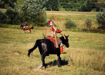 Two knights fight. Medieval armored equestrian soldiers with lances. Riders on  horses are in the...