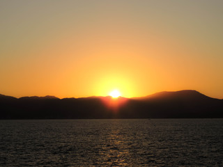 Naklejka premium Sunset between the mountains by the sea