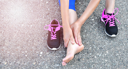 Running injury leg accident- sport woman runner hurting holding painful sprained ankle in pain.Athlete woman has ankle injury, sprained ankle during running training.Space for text