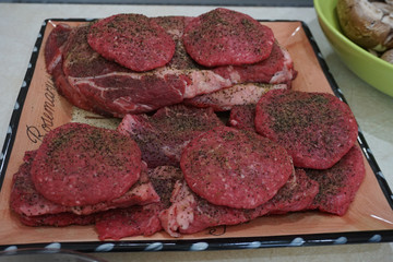 seasoned burgers and steaks ready for grill
