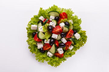 Greek salad on a white acrylic background