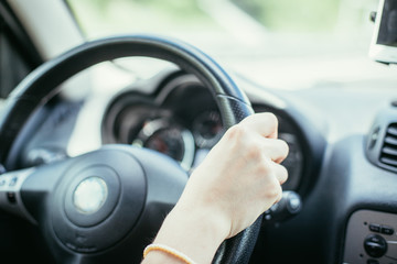 Interieur und Lenkrad eines Autos: Frau sitzt hinterm Steuer