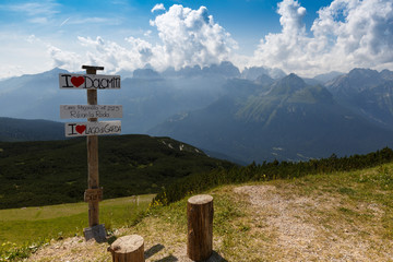 Italy. Dolomites. View from the mountain Paganella. On the left is a nameplate with the name of the area. Summer period.