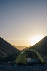 tent in the mountains during a sunset