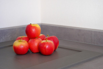 Red juicy apples on gray table in kitchen. Healthy eating concept.