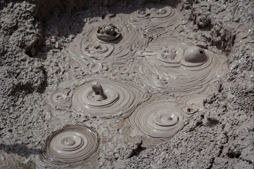 Fototapeta na wymiar Geothermal bubbling mud pool with erupting spouts of mud