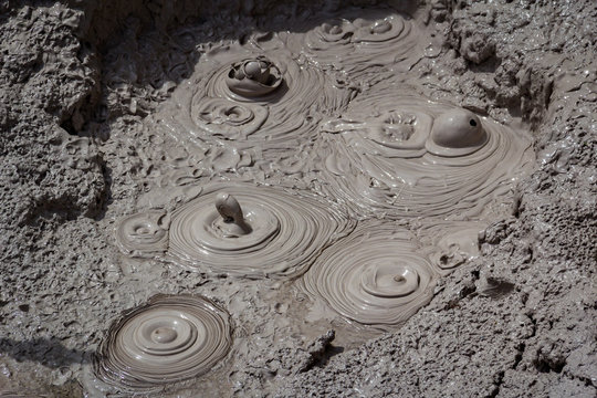 Geothermal bubbling mud pool with erupting spouts of mud - Powered by Adobe