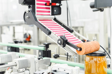 Packing jars of honey in factory.