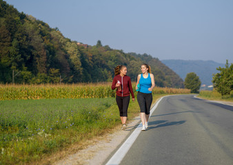 women jogging along a country road