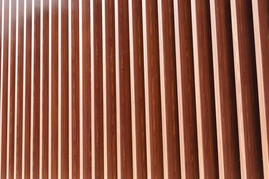 Wooden vertical slats on a wall background. Interior detail, texture, background. The concept of minimalism and Scandinavian style in the interior. Copy space