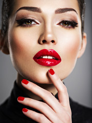Beautiful woman with bright make-up and red nails.