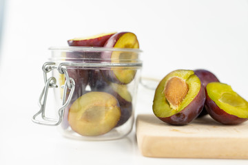 Fresh plums prepared for jam. Tasty fruits on a wooden board in the kitchen.