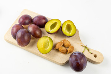 Fresh plums prepared for jam. Tasty fruits on a wooden board in the kitchen.