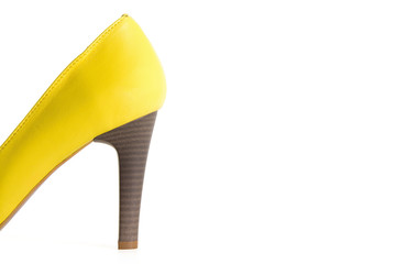 Photo of heels of yellow leather female shoes isolated on a white background.