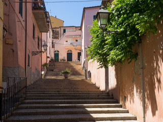 Fototapeta na wymiar Rosafarbene Gasse mit steinerneer Treppe in der Altstadt von Rio Marina, Elba, Italien