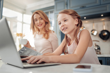 Do not bother me. Silhouette of delighted woman that keeping smile on face and looking at her daughter