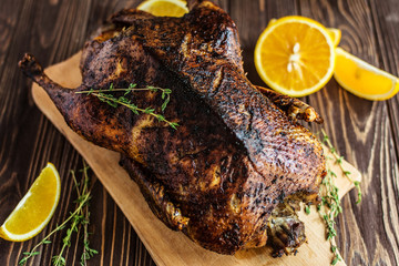 Homemade baked duck with oranges on a wooden background