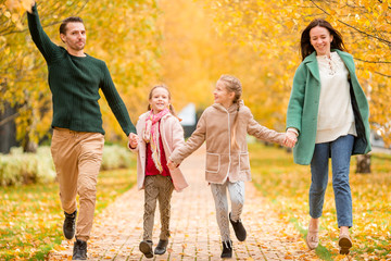 Obraz na płótnie Canvas Portrait of happy family of four in autumn day