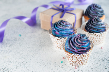 Cupcakes with galaxy whipped cream on party background